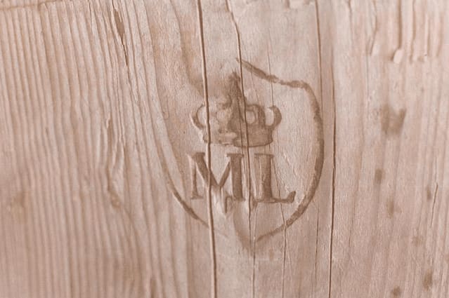 Il monogramma ML, con corona, intagliato nel legno